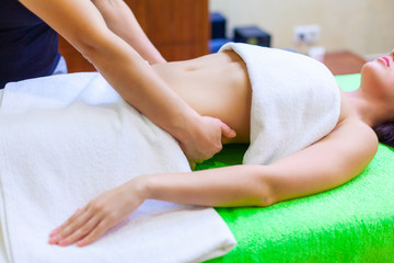 Obraz na płótnie Canvas Top view of hands massaging female abdomen. Woman receiving massage at spa salon