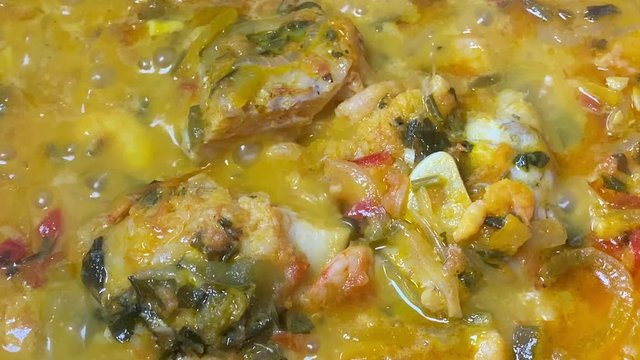 Cooking a moqueca dish. Brazilian traditional food made with fish and shrimp, coconut milk and azeite de dende.