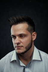 Fototapeta premium ortrait of handsome young man against studio background. Perfect hairstyle, modern stylish haircut. Attractive guy with fashion hairstyle. Confident man with short beard. Barbershop concept.