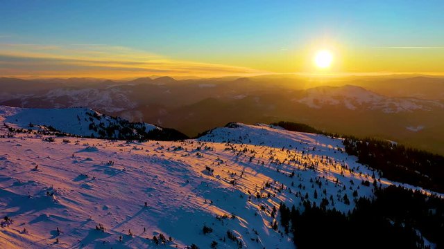 Aerial landscape view from the Ceahlau Mountains National Park and Toaca peak at sunset in the winter season. Aerial view from the drone