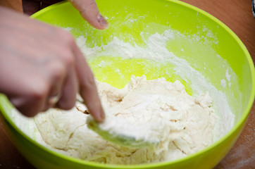 A female hand pours flour into a bowl with yeast and water and sugar. Making pizza  dough