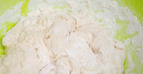 Female hands knead, knead the pizza dough. Dough, flour, cook, pizza. Girl rolls rolling pin  dough