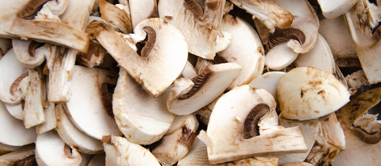 Mushrooms champignon sliced on board. Mushrooms in macro. Hand cuts mushrooms with a  knife