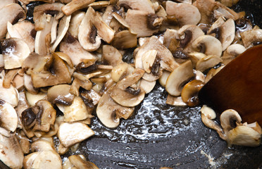 Chopped champignon mushrooms are fried in a pan. Pizza  Mushrooms