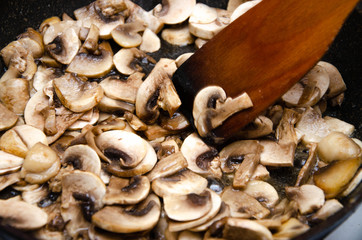Chopped champignon mushrooms are fried in a pan. Pizza  Mushrooms