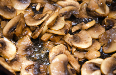 Chopped champignon mushrooms are fried in a pan. Pizza  Mushrooms