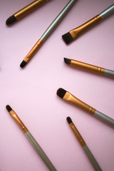 Makeup brushes on a pink background