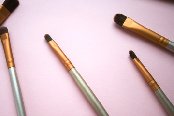 Makeup brushes on a pink background