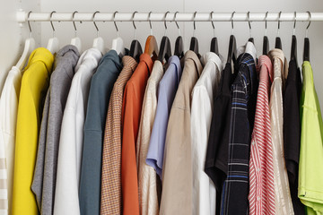 Front view of clothes hung on hangers in the dressing room on the white bar