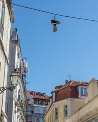 Fototapeta na wymiar shoes on telephone wire in lisboa blue sky summer day