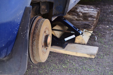 car without wheels on jack close-up repair wheel
