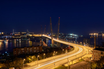 Naklejka na ściany i meble Golden bridge in Vladivostok at night. Night traffic. Golden Bridge in sunset, Vladivostok, Russia.
