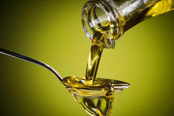 Olive oil  flowing to the spoon