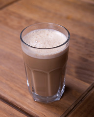 glass of cappuccino on a wooden table
