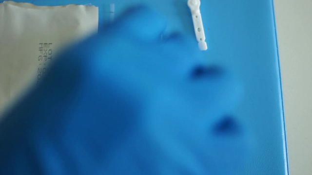 Laboratory assistant lays out a kit for the diagnosis of sars-cov-2 coronovirus - test cassette, reagents, scarifier and disinfectant wipe. Rapid Test Coveid-19