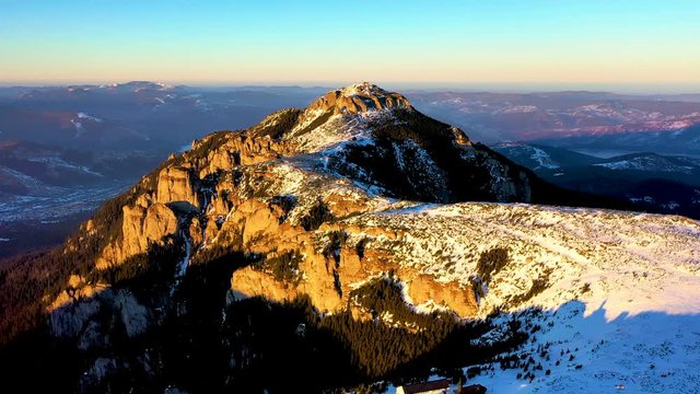 Aerial landscape view from the Ceahlau Mountains National Park and Toaca peak at sunset in the winter season. Aerial view from the drone