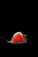 strawberry and sugar on black background
