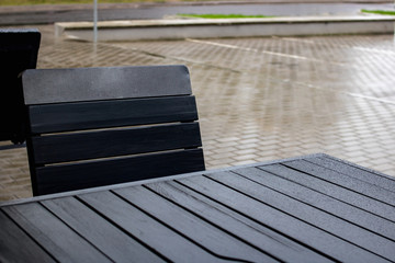 Street table and chair wet in the rain