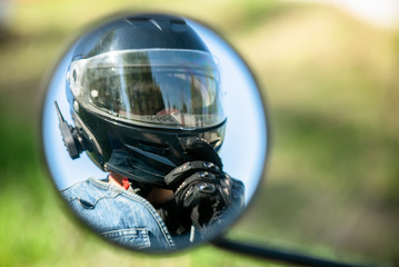 Motor biker reflection in a motorbike mirror close up.
