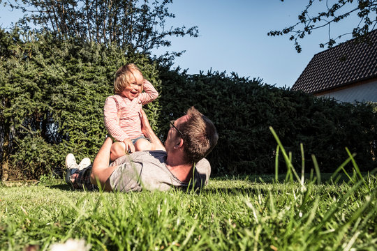 Father playing with little daughter in the garden