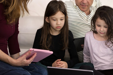 Family doing Lessons with Children on Tablets