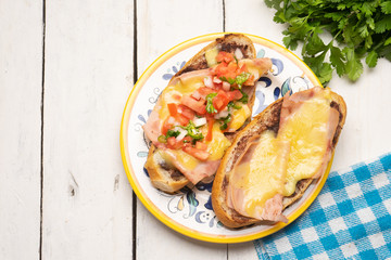 Mexican molletes with ham and cheese on white background