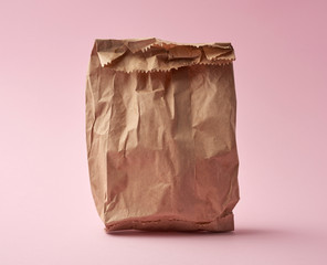full paper disposable bag of brown kraft paper on a pink background