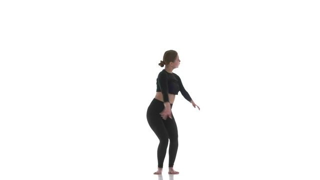 young beautiful girl dancer in black short top and black leggings dancing contemporary, modern ballet dance, isolated, slow motion