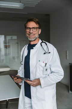Portrait of smiling doctor holding tablet