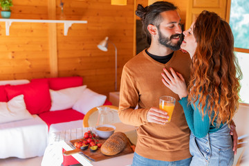 Happy affectionate young couple in a wooden cabin