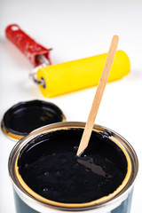 Black paint can and paint roller. Paint application accessories.