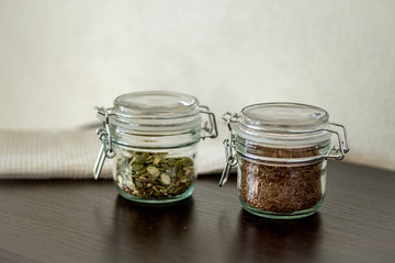 flax seeds in a jar with a lock on the table, pumpkin seeds in a jar with a lock on the table
