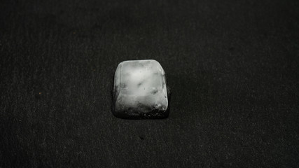 Close-up of melting ice cubes on black background