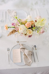 festive table setting with a bouquet of flowers and menu card