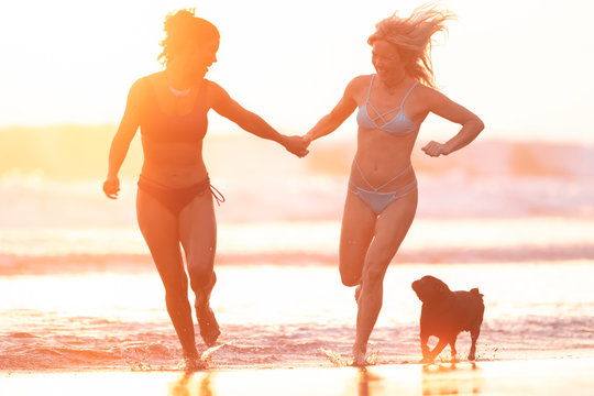 Two happy women runing on the beach at sunset, Costa Rica