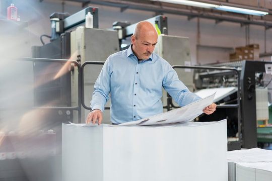 Businessman in a printing plant checking product