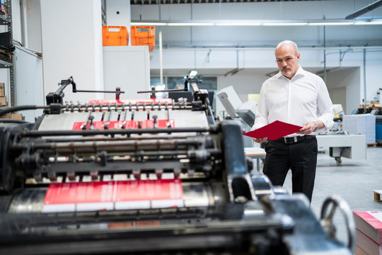 Businessman in a printing plant checking product
