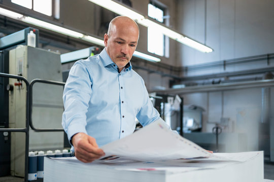 Businessman in a printing plant checking product