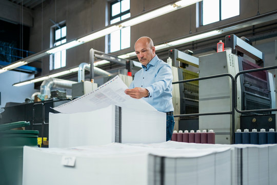 Businessman in a printing plant checking product
