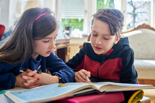 Brother and sister learing at home during school closure
