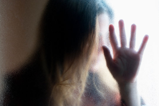 Mature Woman Behind Glass Pane