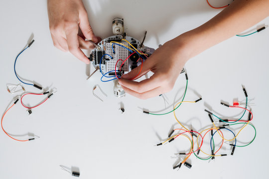 Boy assembling robot on a table, from above