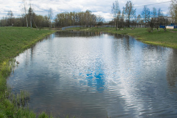 Fototapeta na wymiar Large pond in the Park, visible banks, walking area