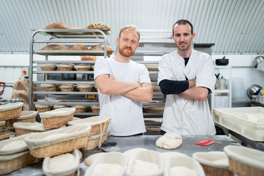 Portrait of two confident bakers in bakery