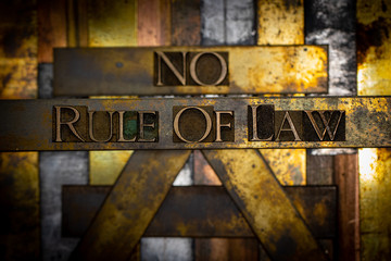 Photo of real authentic typeset letters with selective focus on Rule of Law text on vintage textured grunge copper and black background 