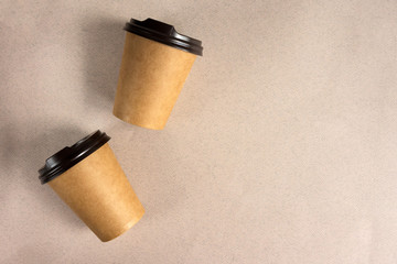 Fototapeta na wymiar Disposable paper cups for coffee on a beige background. Takeaway coffee concept.