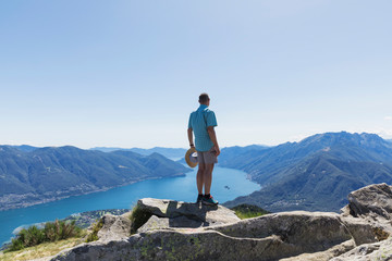 Hiker at Cimetta mountain top looking towards Lago Maggiore and Ascona, Locarno, Ticino, Switzerland