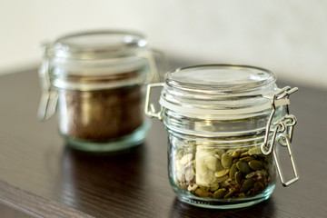 flax seeds in a jar with a lock on the table, pumpkin seeds in a jar with a lock on the table