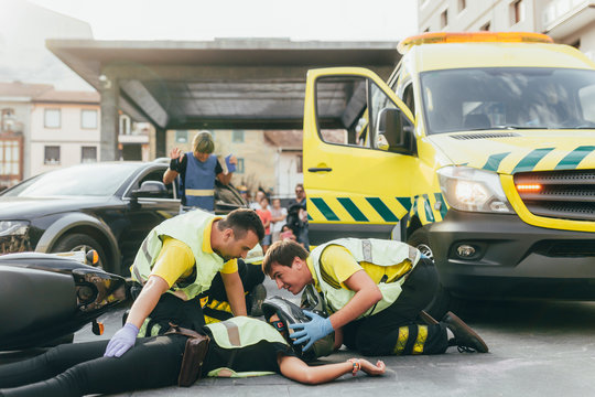 Paramedics helping crash victim after scooter accident