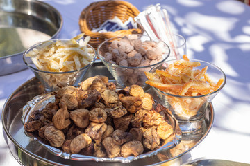 Croatian sweets presented on a plate. Dried fruits like figs, lemons, oranges are sweetened with sugar, and sugared almonds are a typical croatian snack. Served in Cilipi, Dalmatia, Croatia in summer